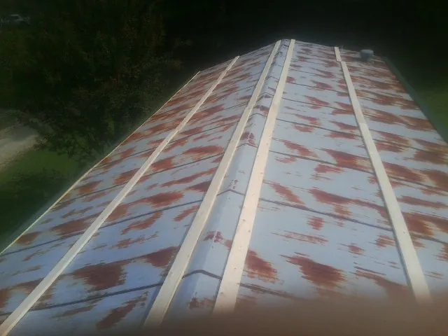 Rusted metal roof panels with new wood purlins before replacement — Storm Damage Roof Repair in Aurora by Roofing Brothers